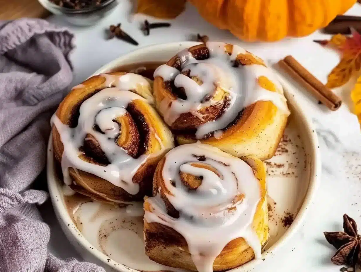 Delicious crescent roll cinnamon rolls topped with icing on a wooden table.