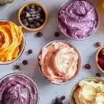 Variety of homemade butter spreads in small bowls on a wooden table
